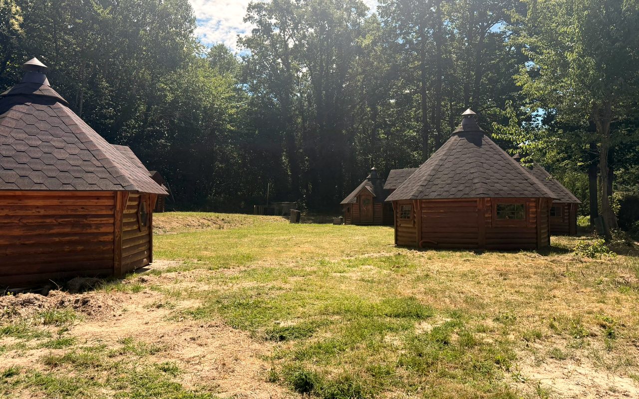 Cabanes en bois rondes des Cabanes de Condé, entourées d'arbres dans les Yvelines